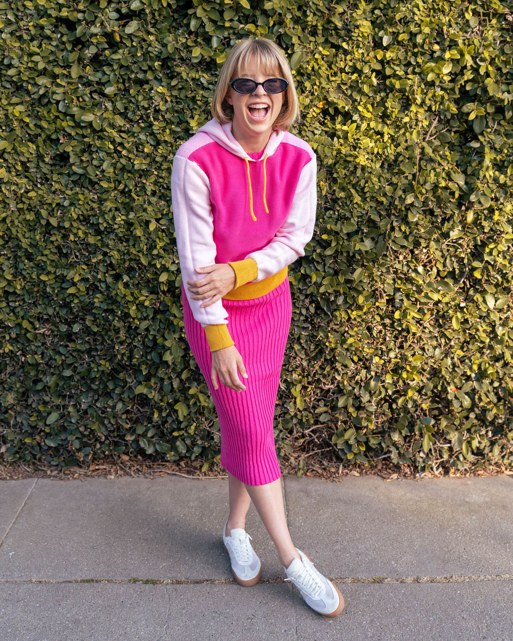 Blythly colorblock hooded sweater in pink colors with yellow accent paired with a pink dress and sneakers