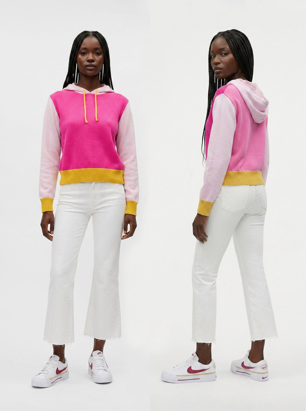 A model is shown from the front and back wearing a color-blocked hoodie with a bright pink and light pink body, a yellow waistband, and white pants with white sneakers.